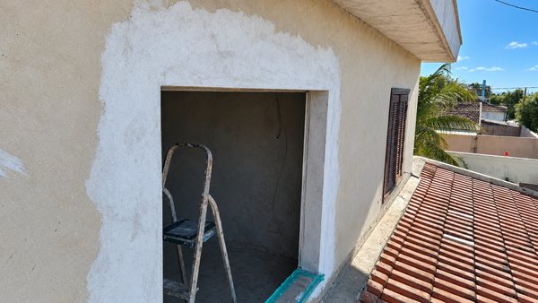 Vão de porta aberto na parede externa, requadrado e com reboco novo