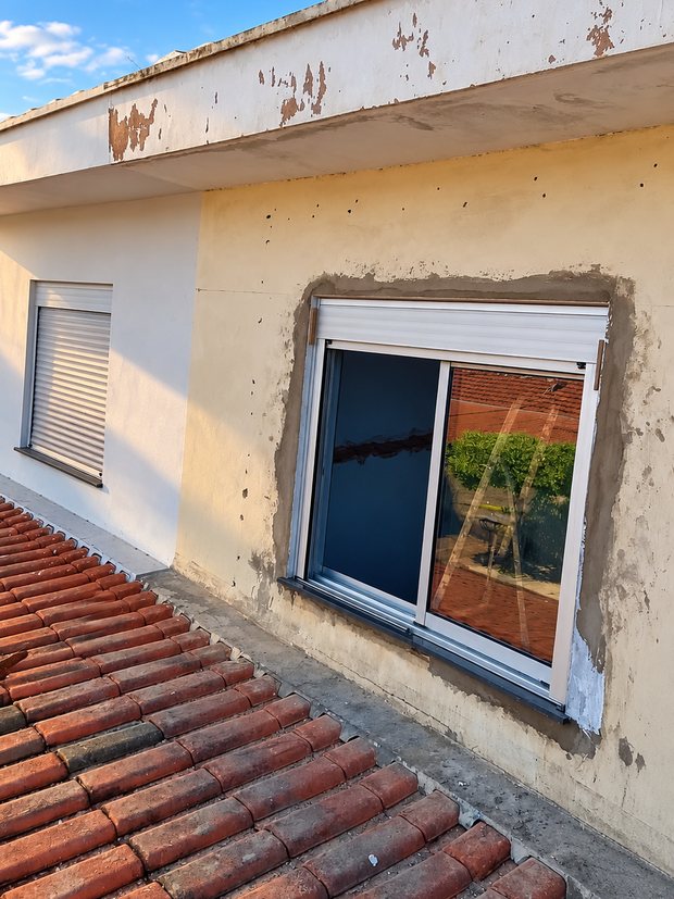 Fachada com a janela recém-instalada e o reboco ainda bruto ao redor do vão